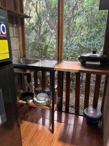 cocina con encimera, fregadero y ventana en Cabañas Hospedaje la Reserva en Hojancha