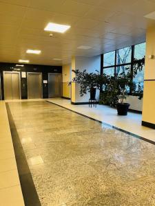 an empty hallway with potted plants in a building at Apartament z panoramicznym widokiem w Centrum in Warsaw