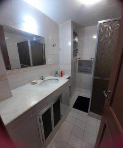 a bathroom with a sink and a shower at Iguabinha Duplex Pé na Areia in Iguaba Grande