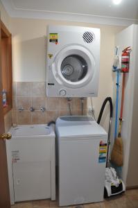 a washing machine and a washer in a room at Blue Wren Cottage in Tumut