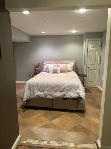ein Schlafzimmer mit einem großen Bett mit rosa Kissen in der Unterkunft The Oasis@Woodyard in Upper Marlboro