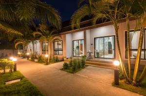 a building with palm trees in front of it at night at Mook Anda Villa in Ao Nang Beach