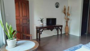 a room with a desk with a television and a chair at Villia magnolia sanur bali 巴厘島玉蘭別墅 in Denpasar