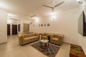 ein Wohnzimmer mit einem Sofa und einem Tisch in der Unterkunft FTP (French Town Palacial) in Puducherry