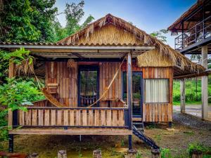 a small wooden house with a thatched roof at Steng Toch Homestay in Phumĭ Bântéay Srei