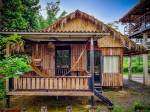 una piccola casa in legno con tetto di paglia di Steng Toch Homestay a Phumĭ Bântéay Srei