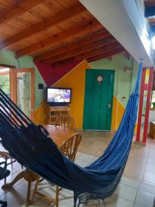a hammock in a room with a table and a tv at La casa de Ana in Ushuaia
