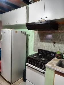 a kitchen with a stove and a refrigerator at La casa de Ana in Ushuaia