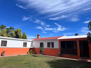Biały i pomarańczowy dom z czerwonym dachem w obiekcie Finca Campestre Los Pinos w mieście Arteaga