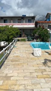 un patio avec une piscine et une clôture ainsi qu'un bâtiment dans l'établissement CASA DE PRAIA AV BEIRA MAR, à Cabo de Santo Agostinho