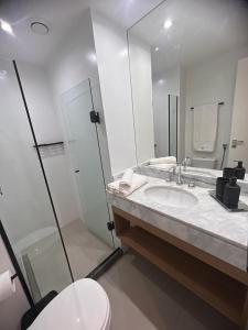 a bathroom with a sink and a toilet and a mirror at Apartamento Praia Flamengo Charme in Rio de Janeiro