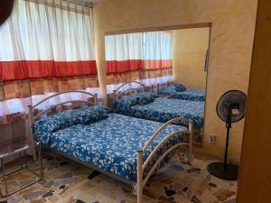 2 Einzelbetten in einem Zimmer mit Ventilator in der Unterkunft Finca MacNoy Casa 12 personas Ixmiquilpan,Hgo cerca balnearios y Tolantongo in Ixmiquilpan