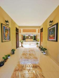 a hallway with potted plants on the floor of a hotel at Hotel Isola by Aiquile in Aiquile