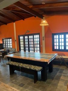 uma grande mesa de pingue-pongue num quarto com janelas em Casa Pé na Areia Sapê em Ubatuba
