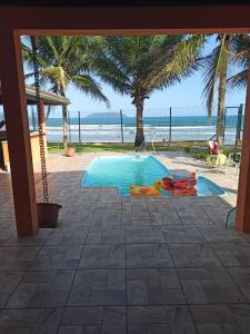uma piscina com vista para a praia em Casa Pé na Areia Sapê em Ubatuba