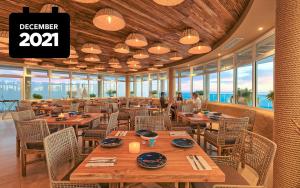 a restaurant with wooden tables and chairs and a clock at ENCANTAME TOWERS VIENTO 203 in Playa Encanto