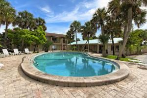 una piscina con un patio de ladrillo y palmeras en The Conch House Marina Resort en St. Augustine