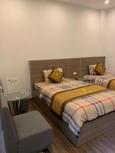 Un dormitorio con 2 camas y una silla. en Hoa Hồng Hotel Sơn La, en Sơn La