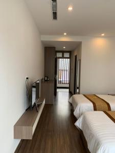 a hotel room with two beds and a television at Hoa Hồng Hotel Sơn La in Sơn La