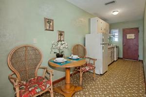 une cuisine avec une table, des chaises et un réfrigérateur dans l'établissement The Conch House Marina Resort, à Saint Augustine