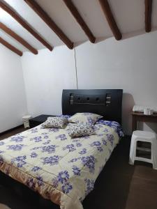 1 dormitorio con 1 cama con edredón azul y blanco en Casona la Vega, en Pasto