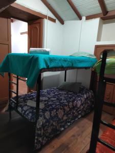 帕斯托的住宿－Casona la Vega，一间卧室配有一张带蓝色床单的双层床