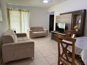 uma sala de estar com um sofá e uma cadeira em Apartamento em Condomínio Marinas Clube em São Pedro da Aldeia