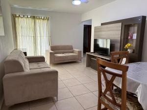a living room with a couch and a chair at Apartamento em Condomínio Marinas Clube in São Pedro da Aldeia