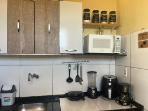 a kitchen with a microwave and a counter top at Apartamento encantador em Lagoinha Paraipaba/CE in Tigre