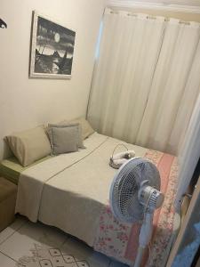a room with a bed with a fan on it at Apartamento encantador em Lagoinha Paraipaba/CE in Tigre