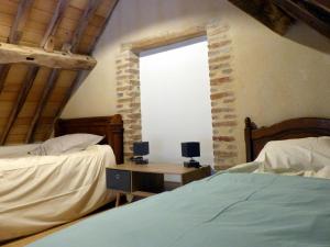 1 dormitorio con 2 camas y ventana en Gîte Lurcy-Lévis, 3 pièces, 6 personnes - FR-1-489-491, en Lurcy-Lévis