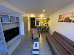 salon z kanapą i telewizorem w obiekcie Espectacular Loft en Bogotá! w mieście Bogota