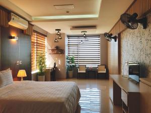 1 dormitorio con 1 cama y TV en una habitación en Khách sạn 20-10 Quảng Bình, en Dong Hoi