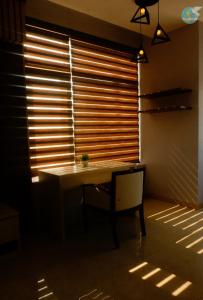una camera con tavolo e finestra con persiane in legno di Khách sạn 20-10 Quảng Bình a Dong Hoi