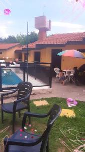 un patio con sillas y sombrilla y una casa en Complejo Altas Cumbres en Villa Cura Brochero