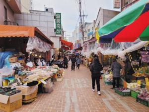 a group of people walking through an outdoor market at SNU Stay in Seoul