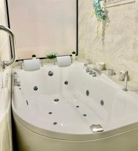 een badkamer met een wit bad en een douche bij Luxury Mocawa House: Two Jacuzzis, Pool & BBQ. in La Tebaida