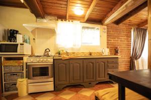 a kitchen with a stove and a microwave at Cabaña Robertino in El Bolsón