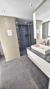 a bathroom with a sink and a shower at Twin Sands Resort Penthouse in Patong Beach
