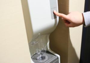 a hand pointing at a wine glass in a machine at APA Hotel Nambaminami Daikokucho Ekimae in Osaka