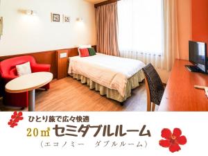 ein Hotelzimmer mit einem Bett, einem Tisch und einem Schreibtisch in der Unterkunft Sun Palace Kyuyokan in Naha