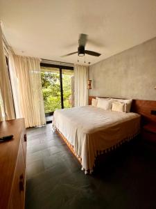 Schlafzimmer mit einem Bett und einem Deckenventilator in der Unterkunft Tu mejor opción en Tulum in Tulum