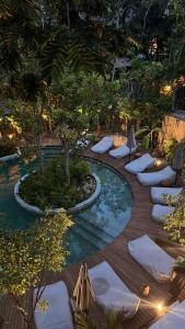 einen Pool mit Kissen und Stühlen im Garten in der Unterkunft Tu mejor opción en Tulum in Tulum