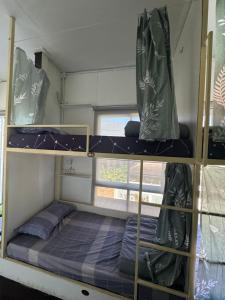 a small room with two bunk beds and a window at Baan Chiang Maan in Chiang Mai