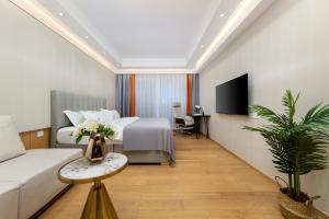 a hotel room with a bed and a tv at East Maple International Apartment - Guangzhou International Financial City Keyun Road Metro Station in Guangzhou
