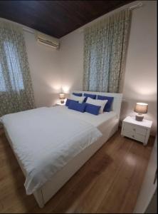 a bedroom with a large white bed with blue pillows at Casa Arokaria in Pendarianá