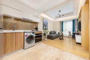 a kitchen and living room with a washing machine at East Maple International Apartment - Guangzhou International Financial City Keyun Road Metro Station in Guangzhou