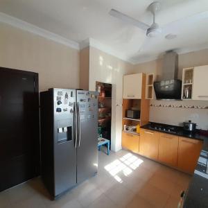 a kitchen with a stainless steel refrigerator and cabinets at Chateau Eyram in Accra