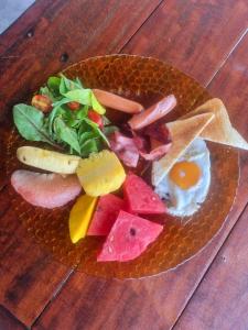 un plato de comida con un huevo y frutas y hortalizas en CyKali Garden Bungalows, en Wok Tum