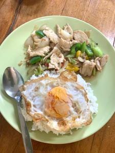 a plate of food with an egg and rice and mushrooms at kohkoodfarmstay in Ban Ao Yai